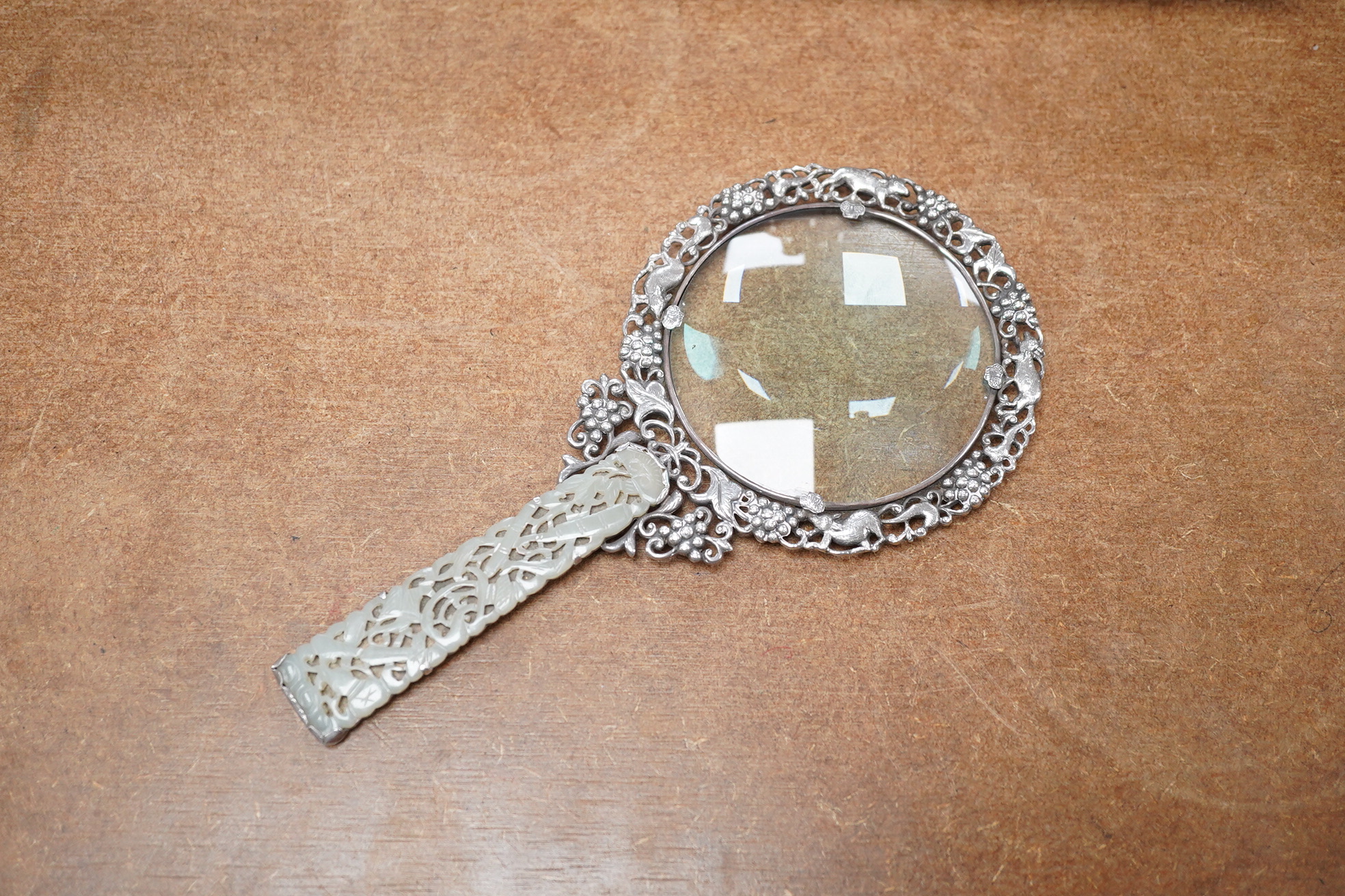 A Chinese white metal and pale celadon jade handled magnifying glass, early 20th century, stamped ‘SILVER’, 19cm long. Condition - good